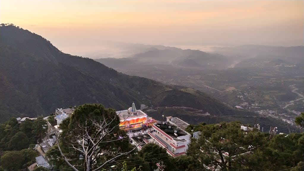 Breathtaking aerial view of Katra with mountains and buildings at twilight, creating a serene and picturesque scene.
