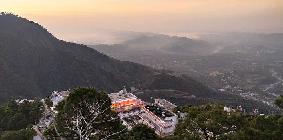 Breathtaking aerial view of Katra with mountains and buildings at twilight, creating a serene and picturesque scene.