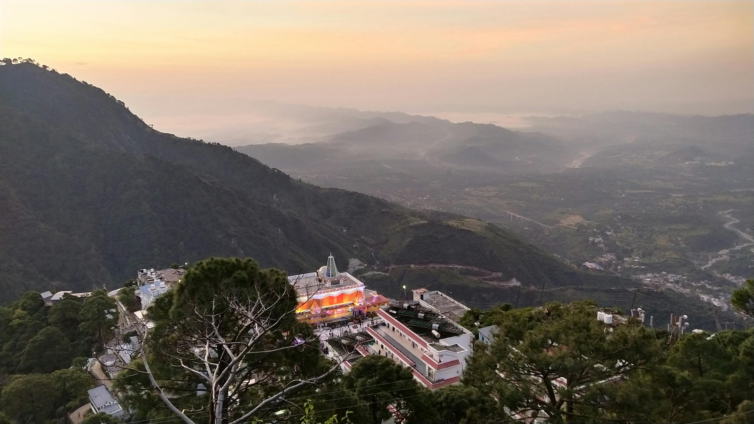 Breathtaking aerial view of Katra with mountains and buildings at twilight, creating a serene and picturesque scene.