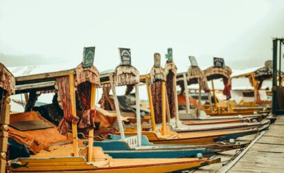 Vibrant shikaras docked by a serene lake, offering a traditional touch of Kashmir's beauty and culture.