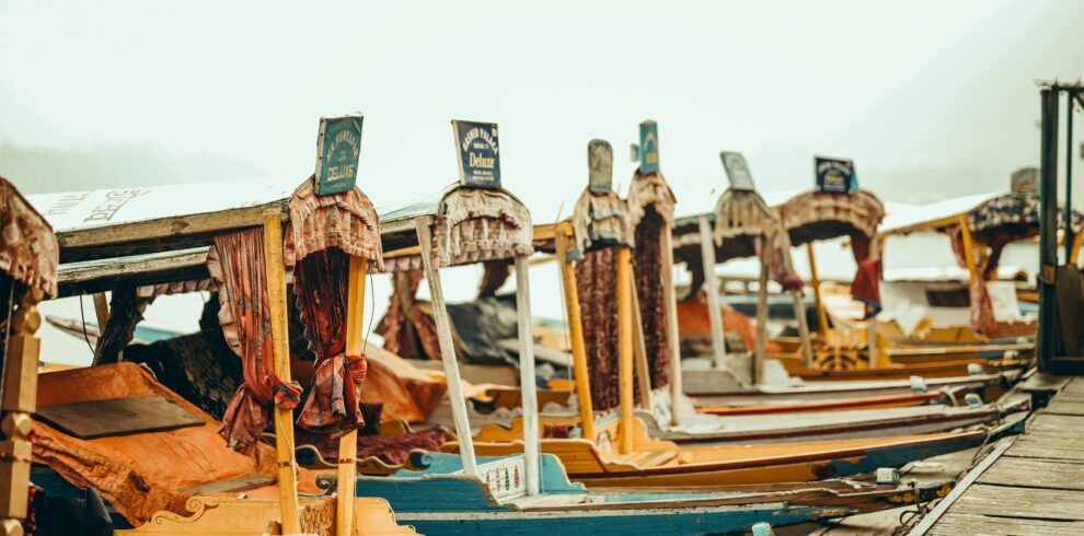 Vibrant shikaras docked by a serene lake, offering a traditional touch of Kashmir's beauty and culture.